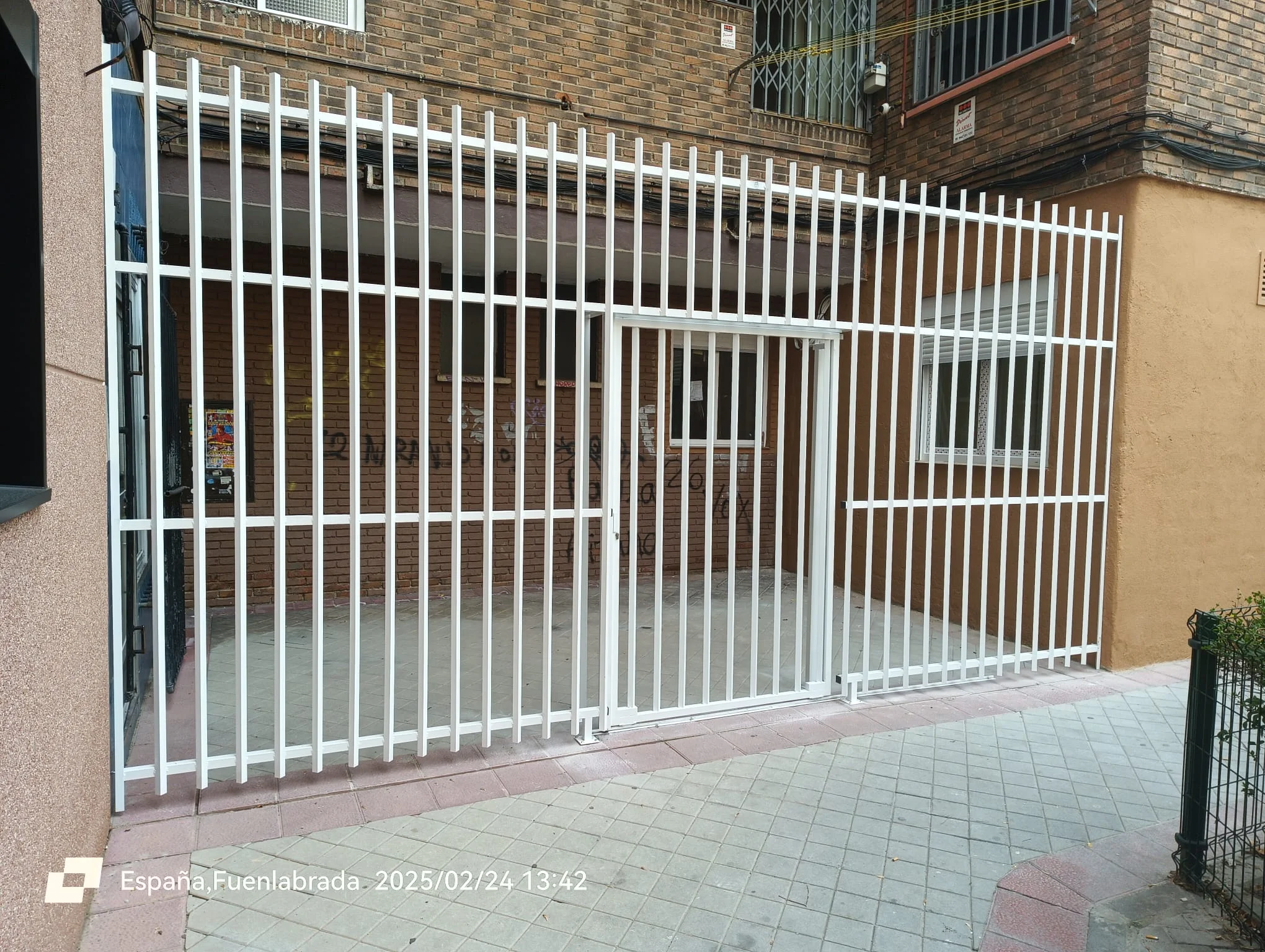 Reja de cerramiento perimetral con barrotes verticales y cancela peatonal lacada en blanco en Fuenlabrada