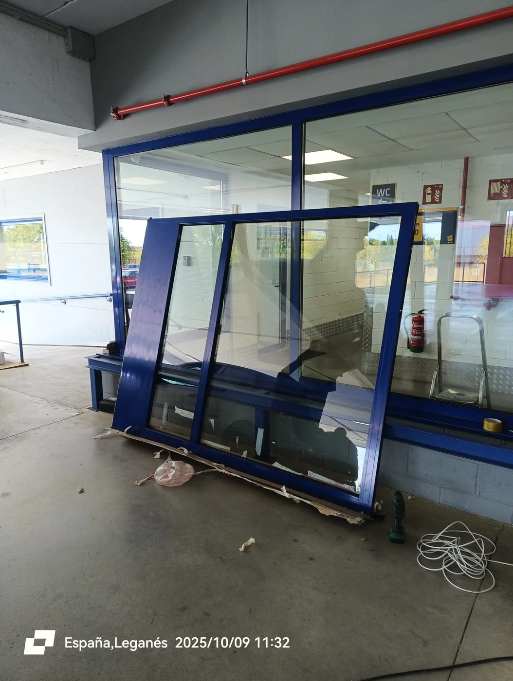 Hoja acristalada con perfilería de aluminio lacada en azul durante su montaje en Leganés